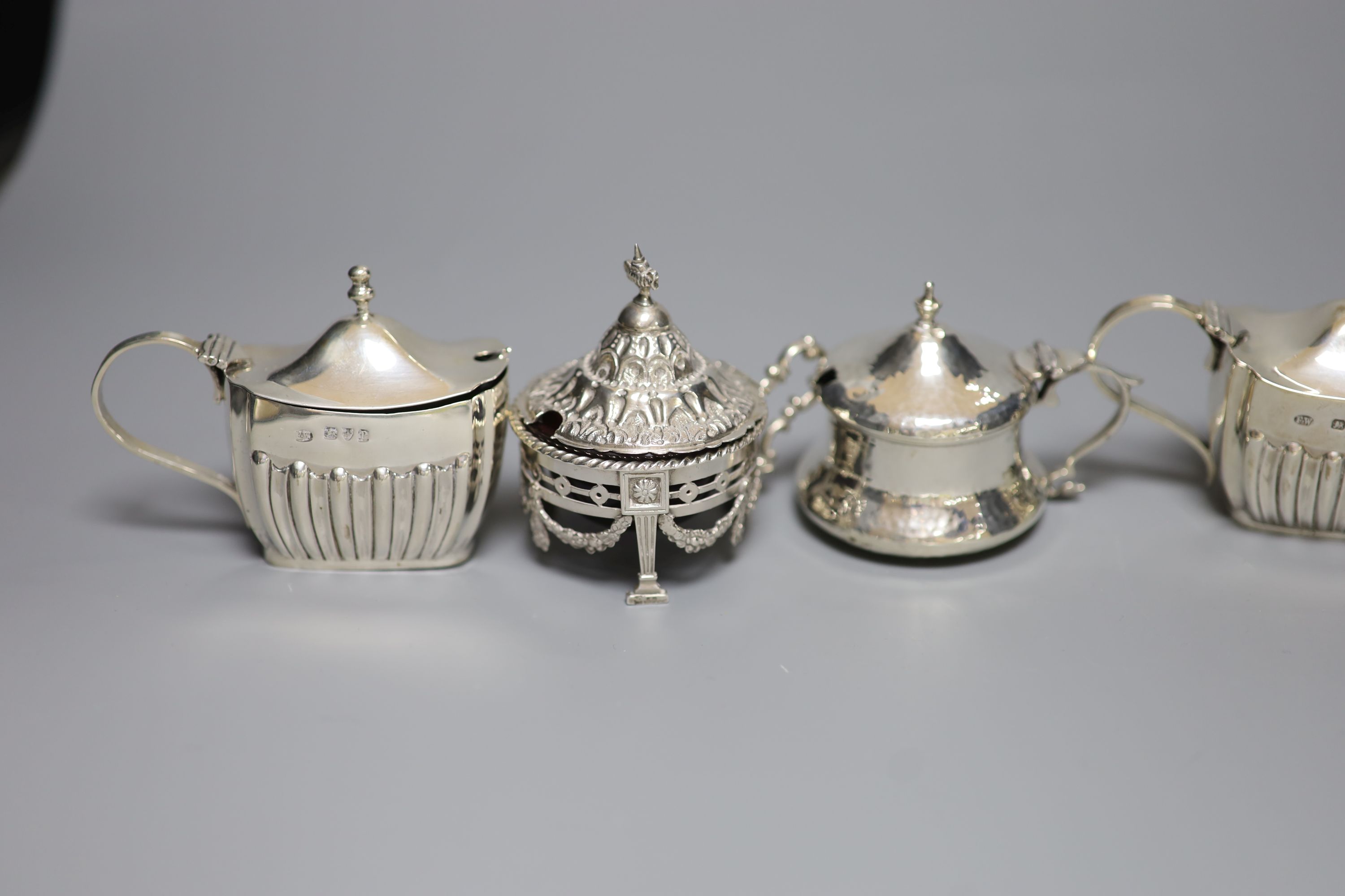 An ornate silver circular mustard with ruby glass liner and six other silver mustards, Victorian and later, approx 12oz